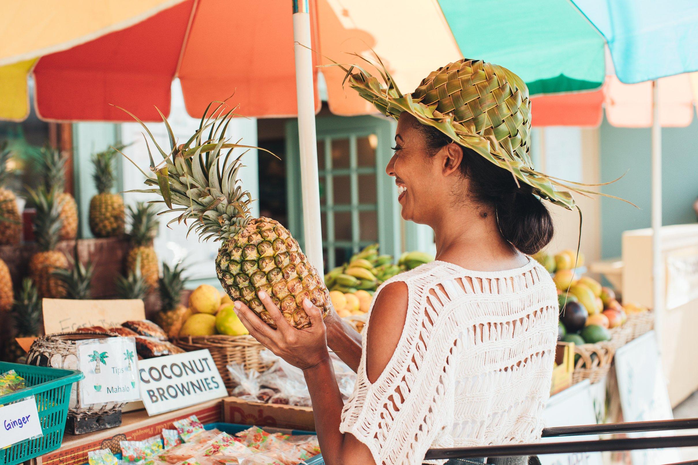 How to Boost Your Immune System for Your Next Family Vacation - woman buying a pineapple from a fruit vendor
