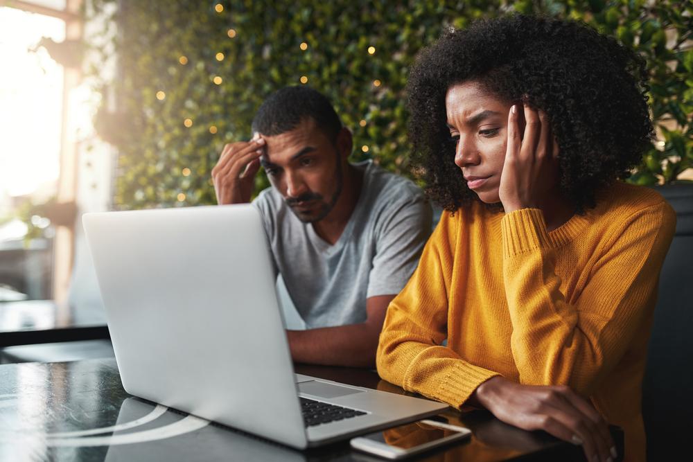 Stressed young couple Making Booking a Vacation Harder than It Needs to Be