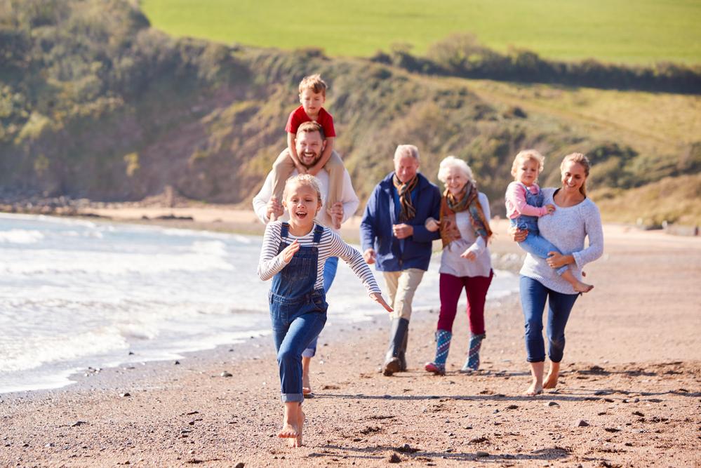Multigenerational Vacation Ideas for Families - Multigenerational Family Walking Along a Beach
