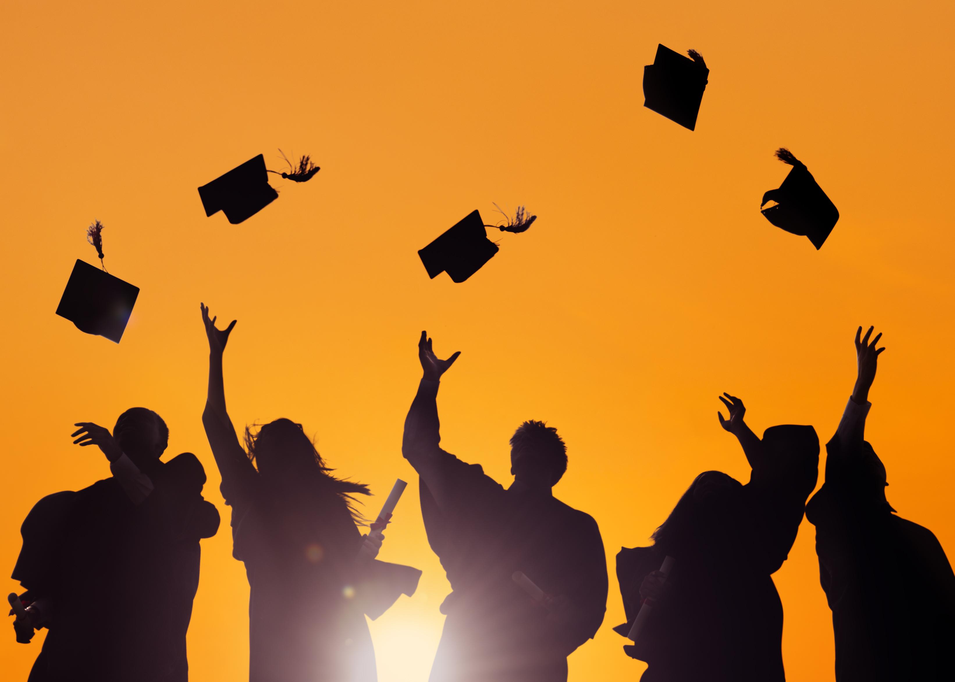 Celebrate Your Graduate with a Surprise Trip to One of These Destinations - Students Throwing Their Caps at Graduation